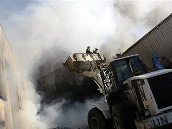 Пожарные тушат склады ООН в Газе, загоревшиеся в результате израильского авиаудара. Фото ©AFP, архив