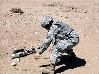 Американский военнослужащий в Афганистане готовится к разминированию неразорвавшегося снаряда. Фото ©AFP